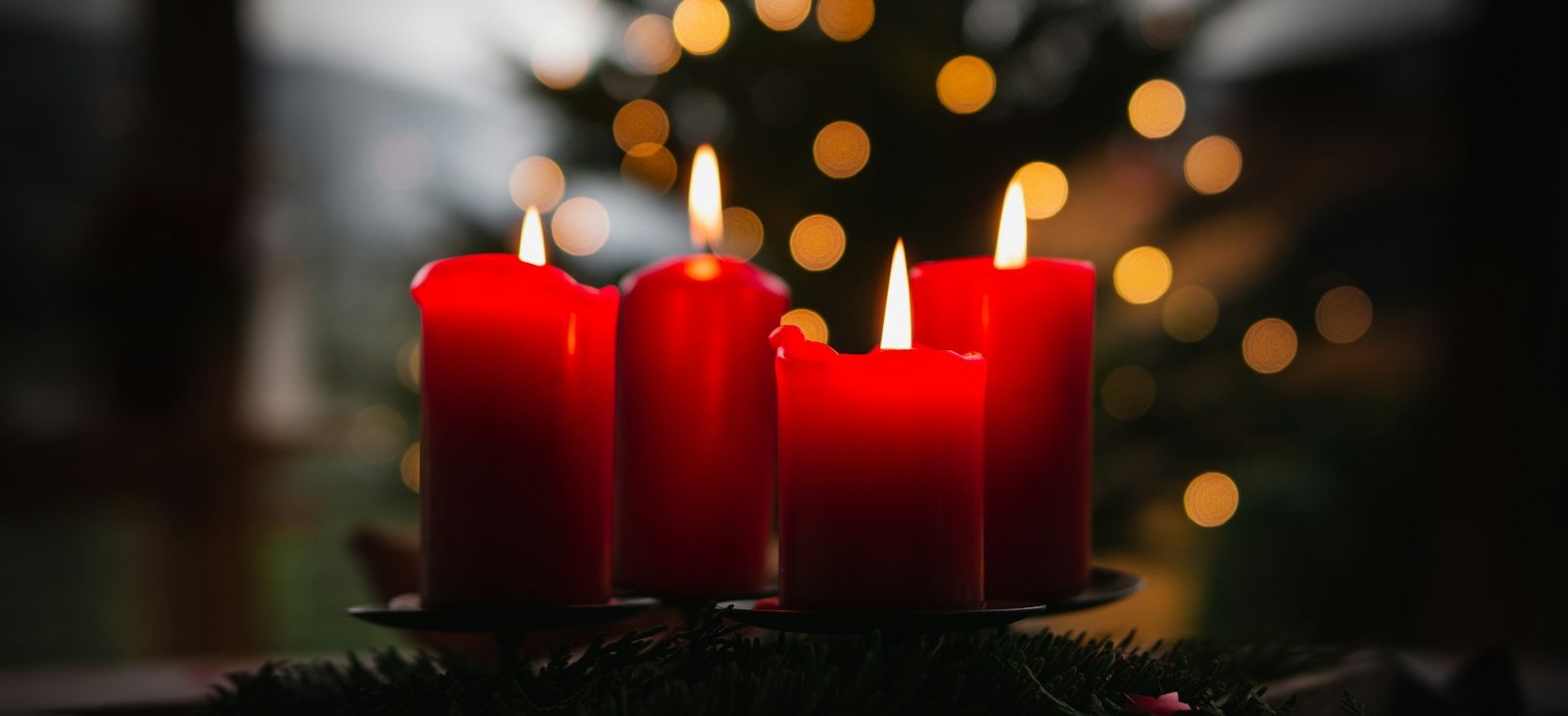 shallow focus photo of four red lighted candles